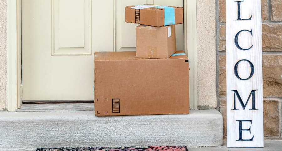 Packages on the doorstep of a home with a welcome sign in Greensboro